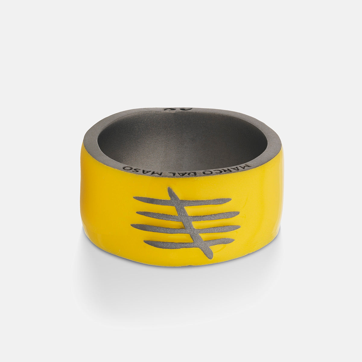 Yellow and gray ring with engraved design on a white background
