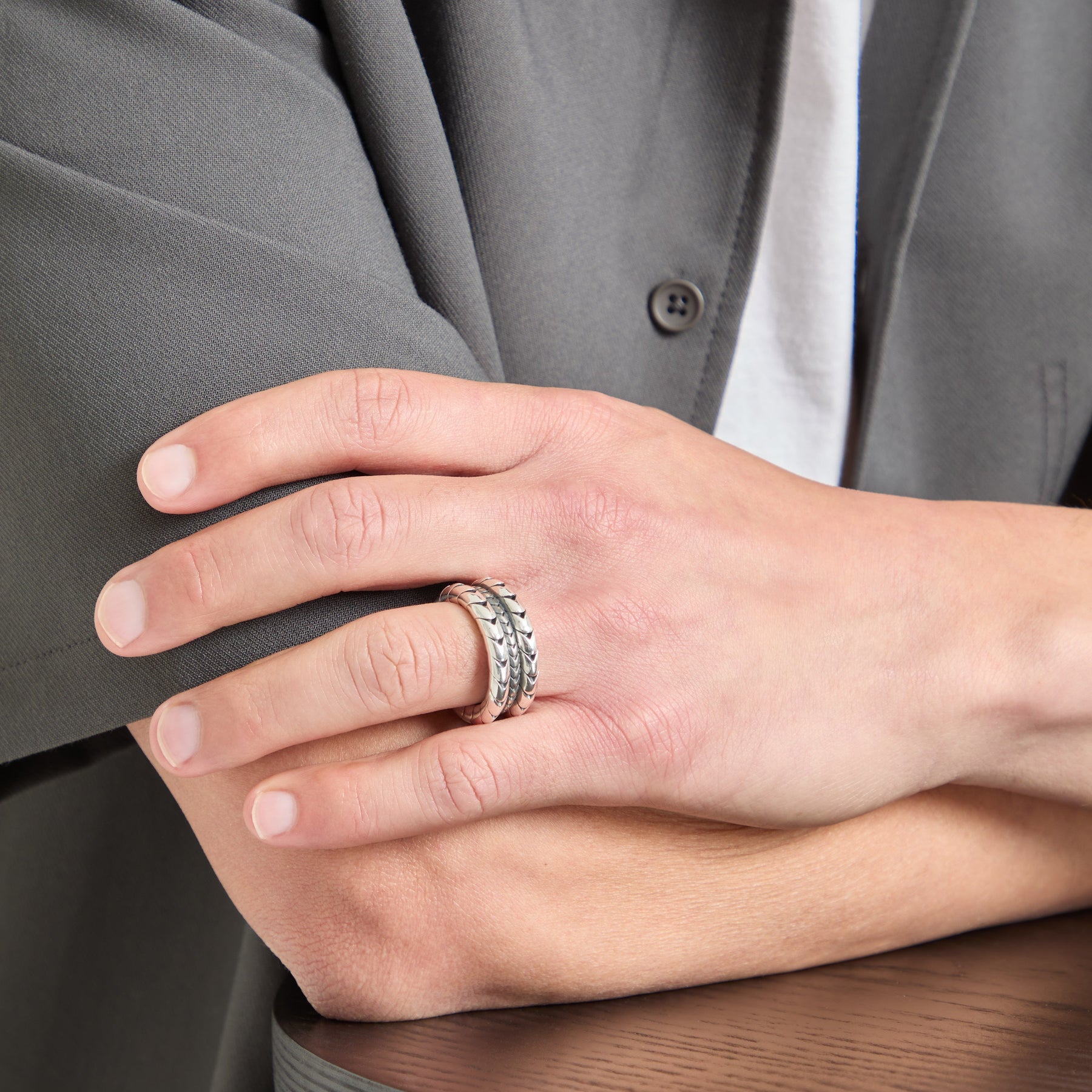 Model wearing the Iron Snake polished silver ring on ring finger.