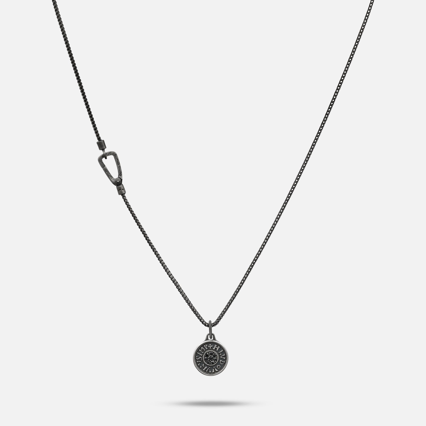 Silver necklace with a round pendant on a light gray background
