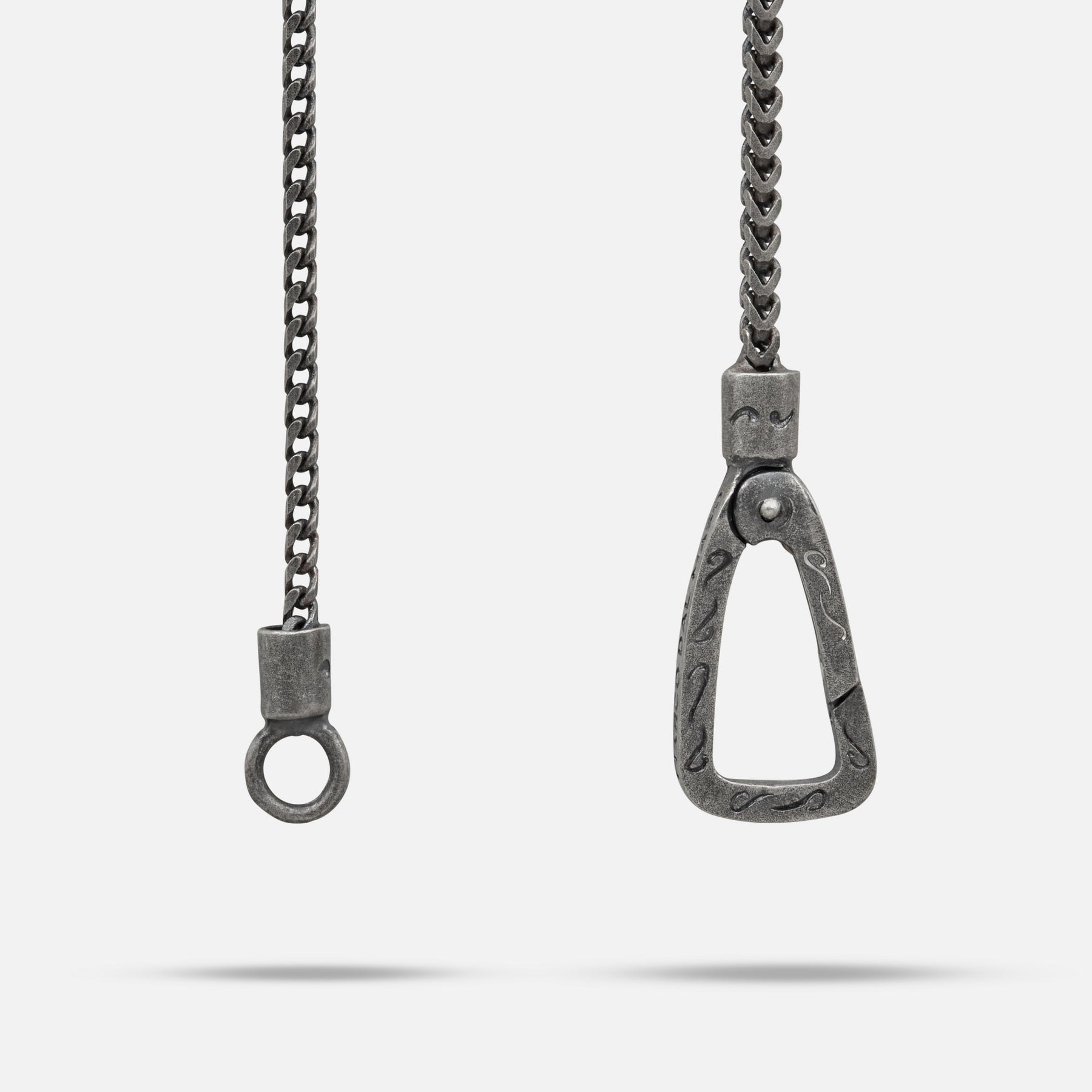 Metallic chain with a horse bit pendant on a white background
