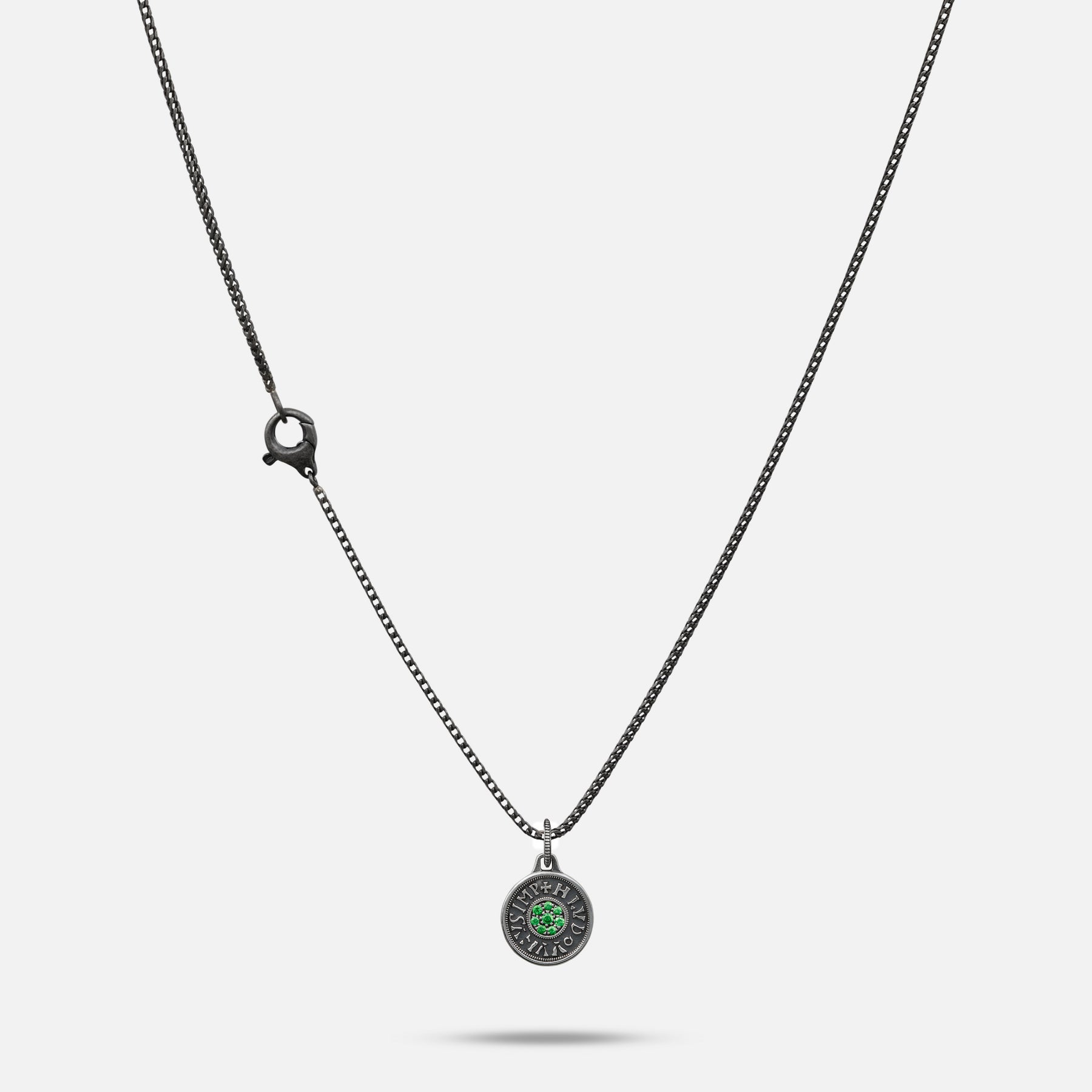 Necklace with a round pendant featuring a green gemstone on a white background