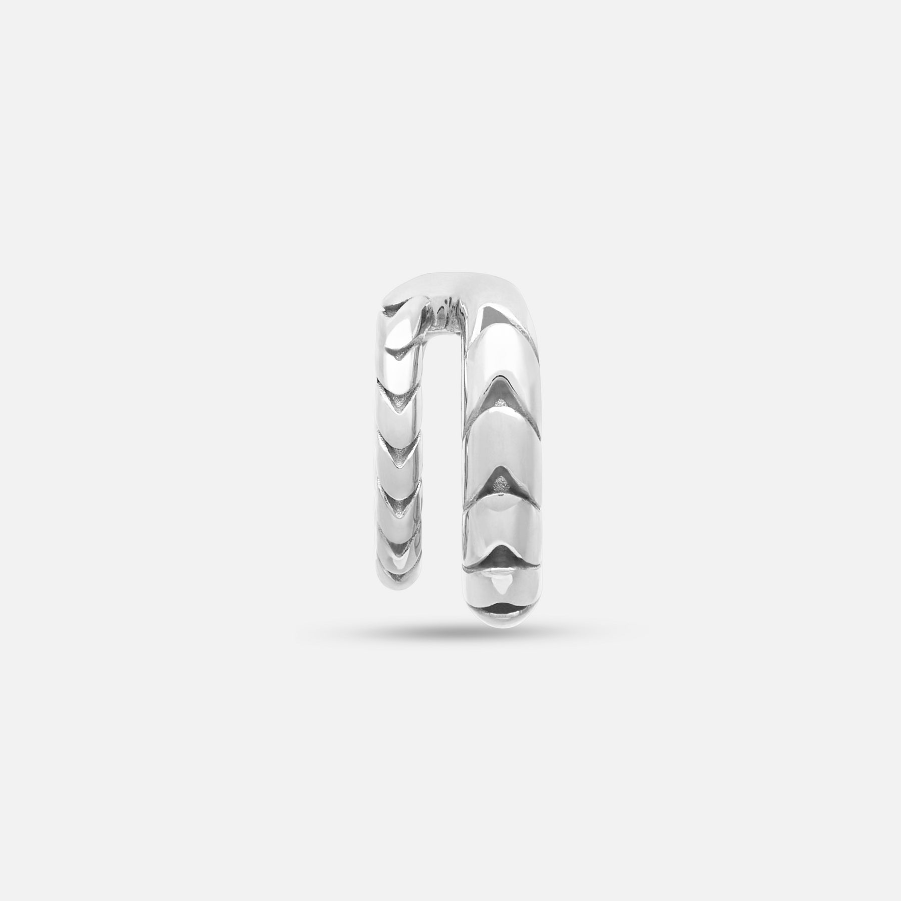Front view of polished silver Iron Snake ear cuff on display.