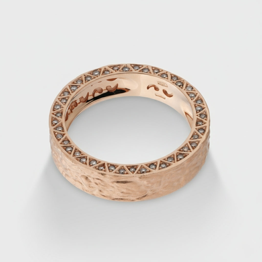 Rose gold ring with diamond accents on a light gray background
