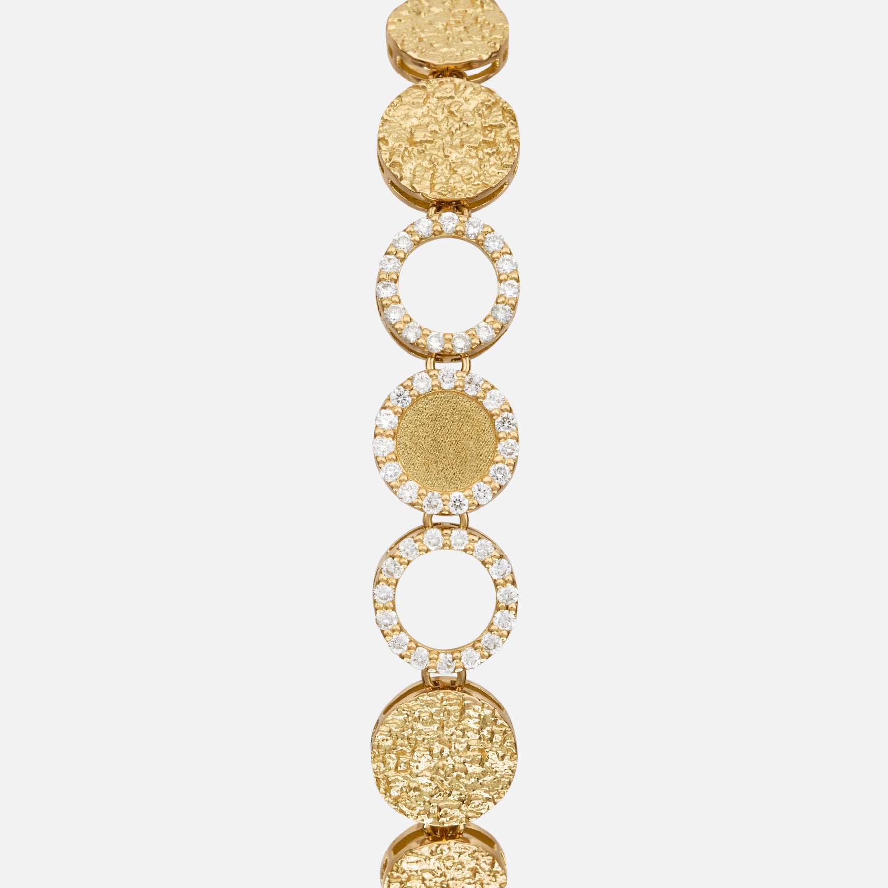 Close-up of the Frammenti Cascade Bracelet, featuring circular links in 18K yellow gold with alternating textured surfaces and white diamond accents.