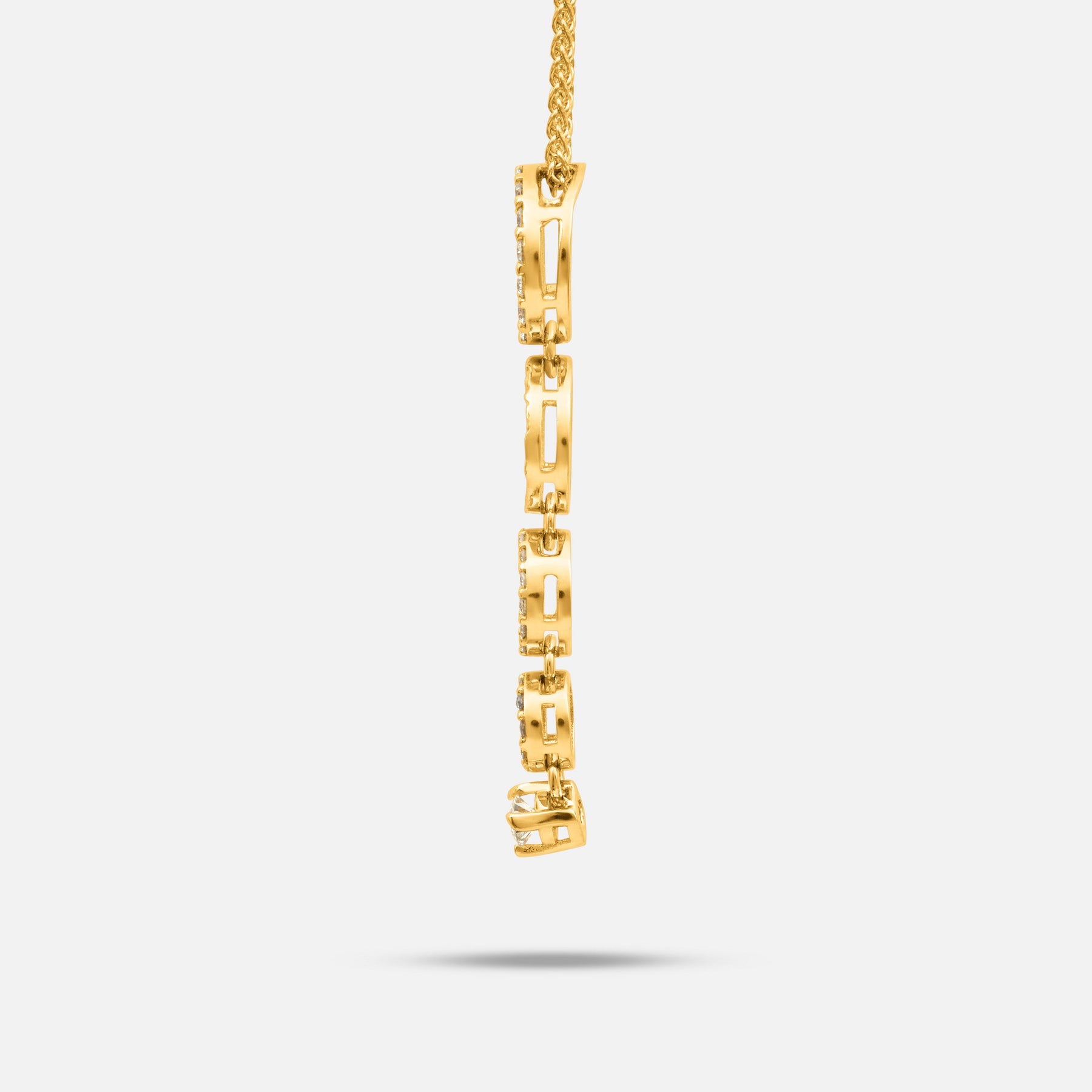 Side view of the Frammenti Cascade Pendant in matte 18K yellow gold, featuring linked segments accented with white diamonds.