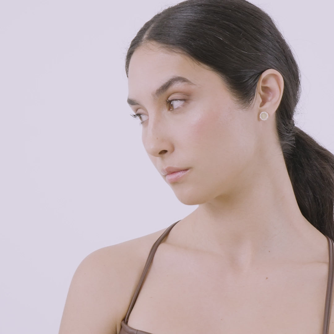 Video showcasing the Frammenti Halo Stud Earrings in 18K matte gold, worn by a model in soft natural lighting.