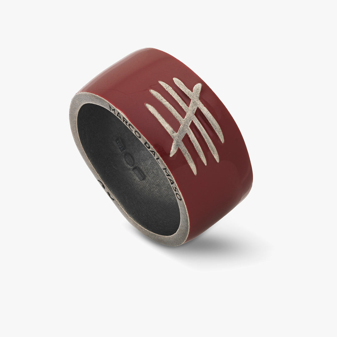 Red ring with silver design on a white background