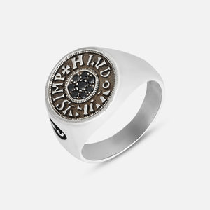 Silver ring with a detailed circular design on a white background