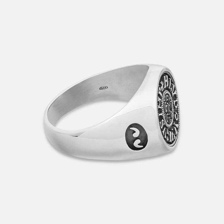 Silver ring with a black circular design on a white background