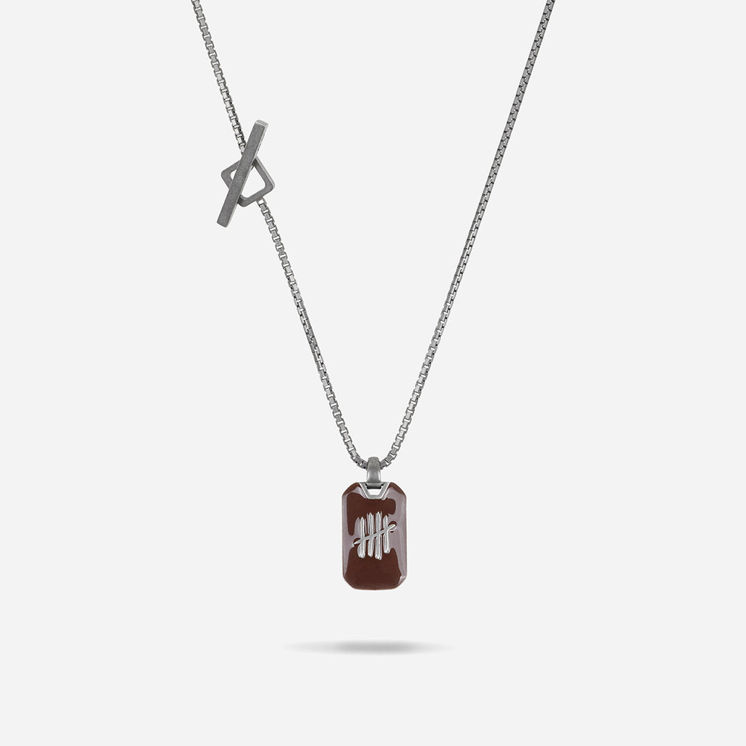 Necklace with a brown pendant and silver chain on a white background