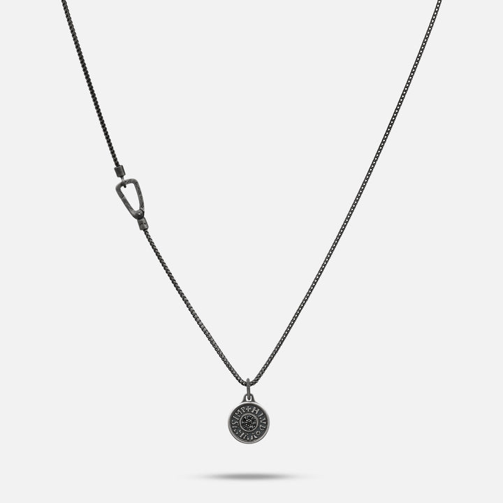 Silver necklace with a round pendant on a light gray background