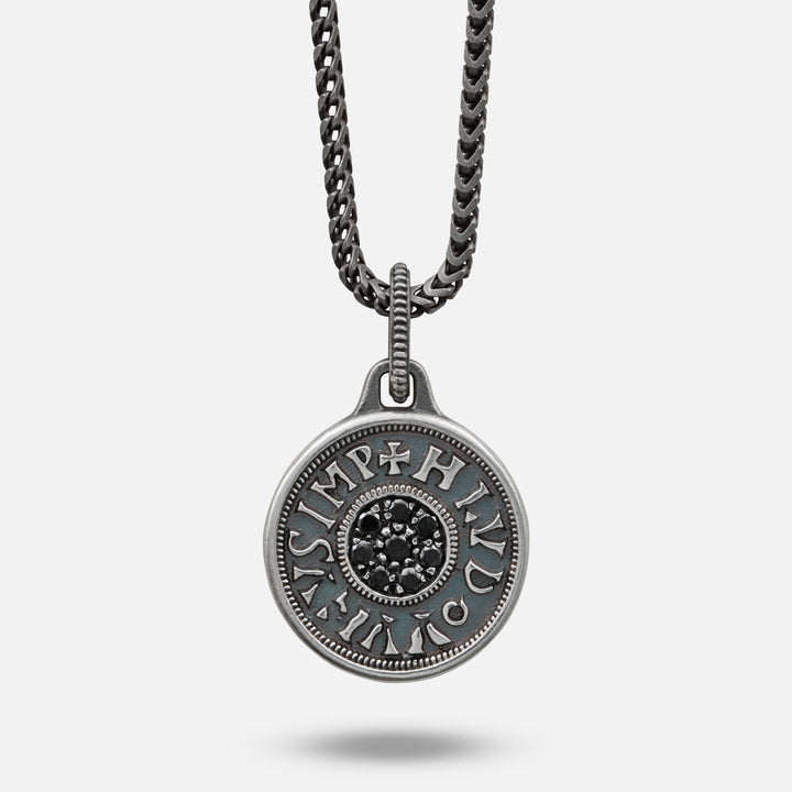 Silver pendant necklace with chain on a light gray background