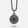 Silver pendant necklace with chain on a light gray background
