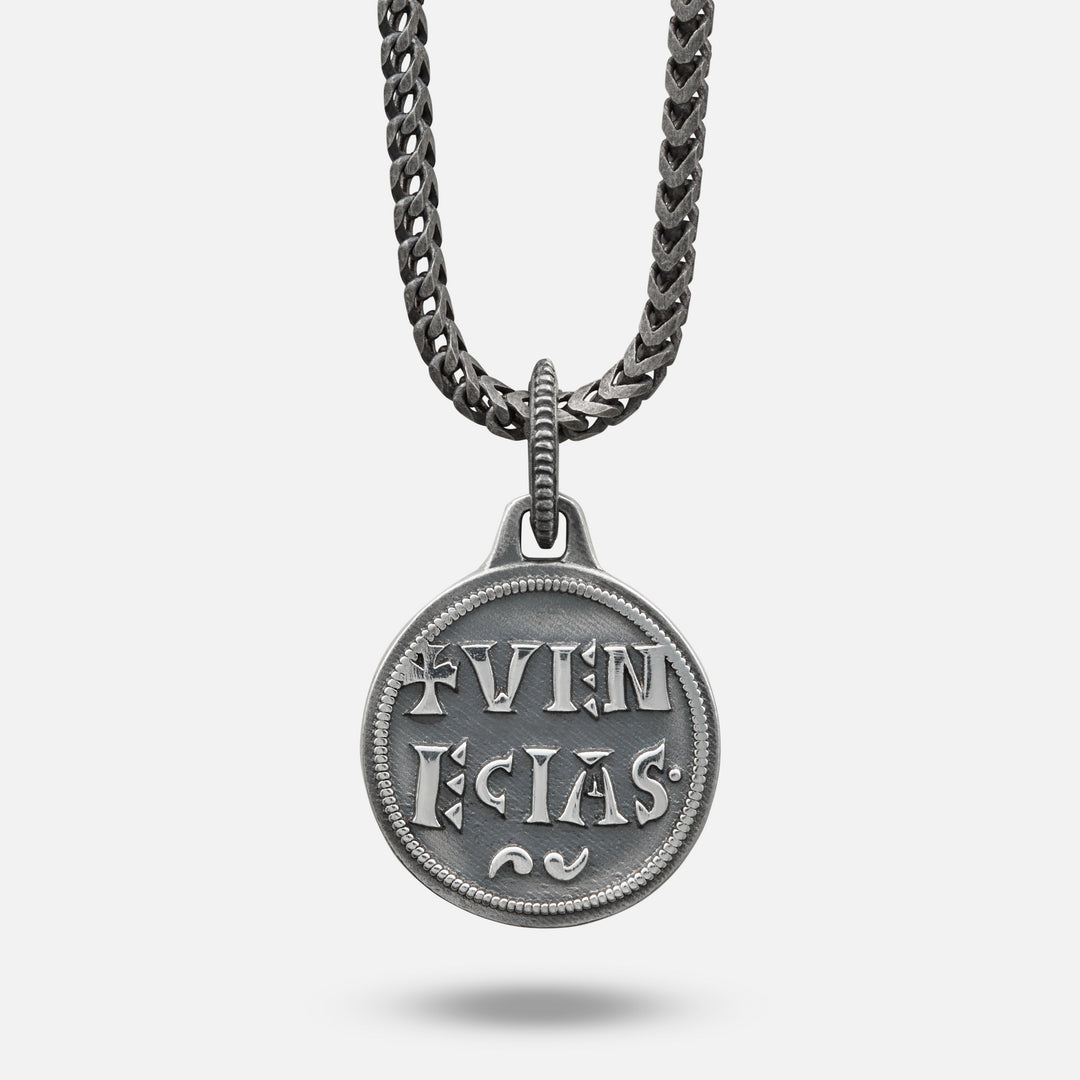 Silver pendant necklace with engraved text on a white background