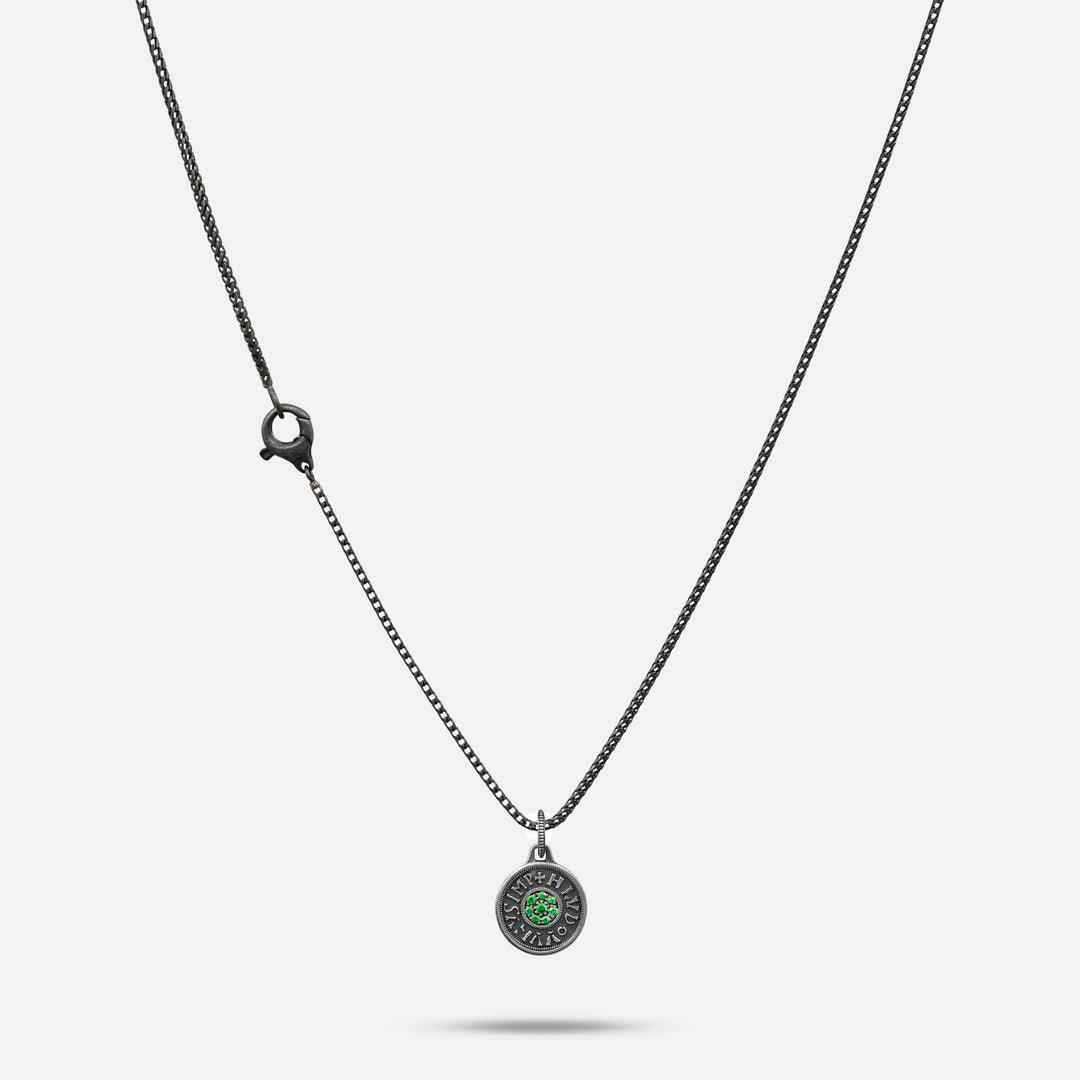 Necklace with a round pendant featuring a green gemstone on a white background