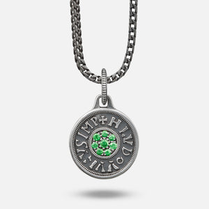 Silver pendant with green gemstones on a chain against a white background