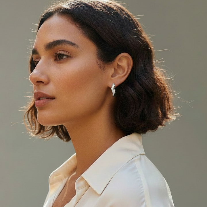Woman wearing a light-colored blouse against a neutral background