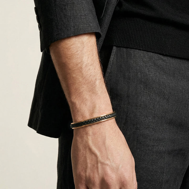 close up of male model wearing The Lash Wide Braided Black Leather Cuff is made from braided Italian leather and features an 18K Yellow Gold Vermeil finish - AGSC6-01YESBPN-XS