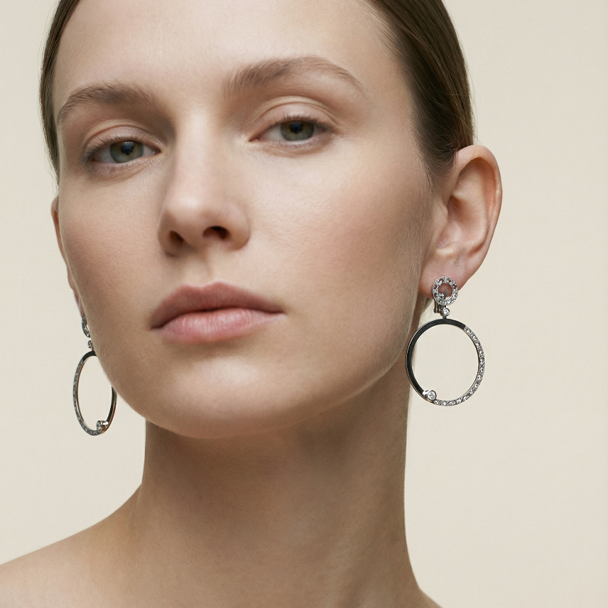Woman wearing hoop earrings on a beige background