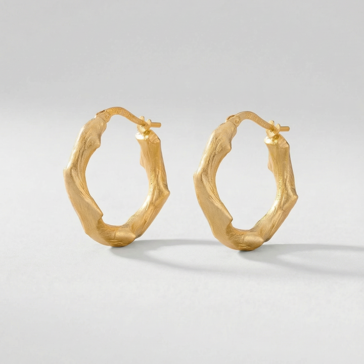 Gold hoop earrings on a light gray background