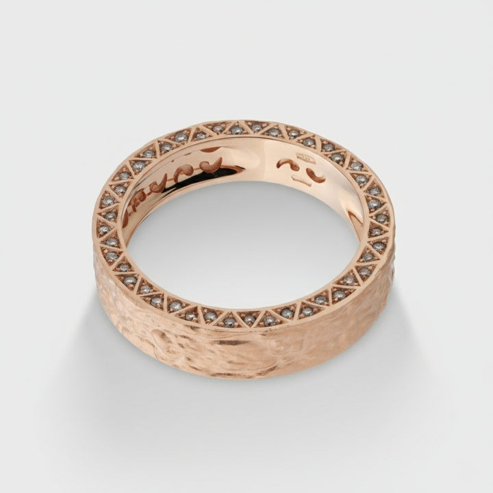 Rose gold ring with diamond accents on a light gray background