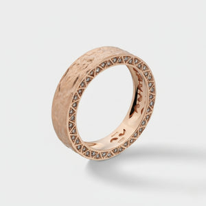 Rose gold ring with diamond accents on a light gray background