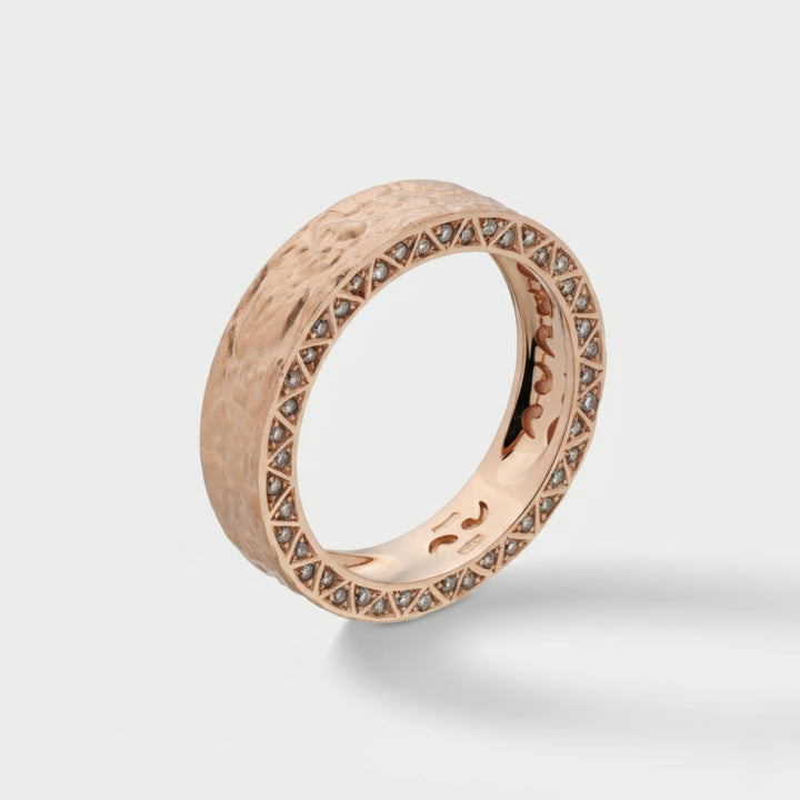 Rose gold ring with diamond accents on a light gray background