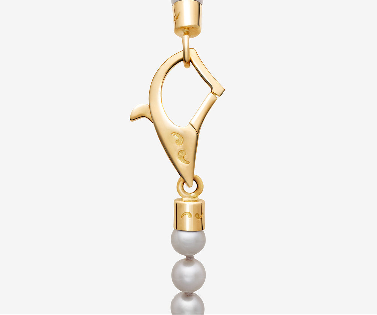 Gold clasp with pearl beads on a white background