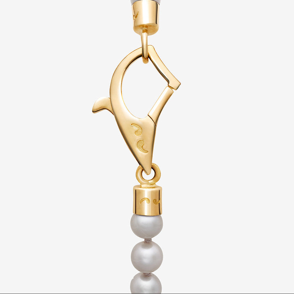Gold clasp with a pearl on a white background