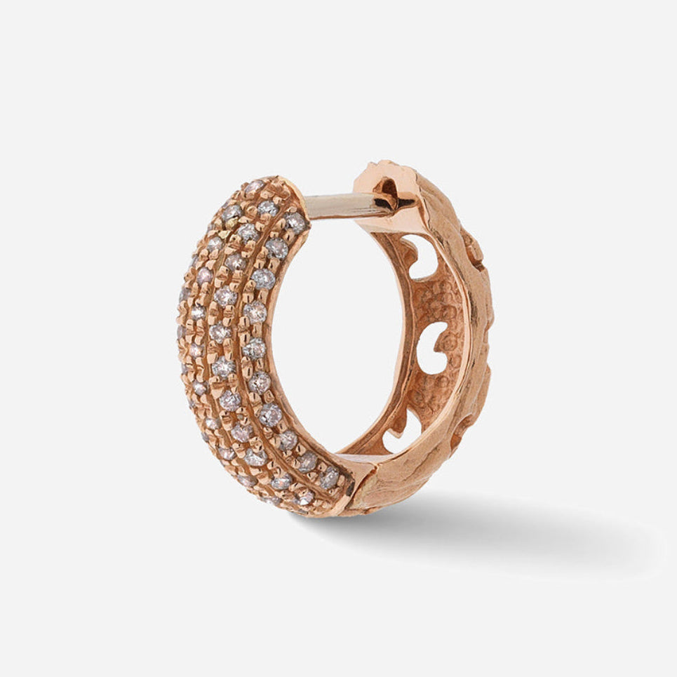 Rose gold hoop earring with embedded stones on a light gray background