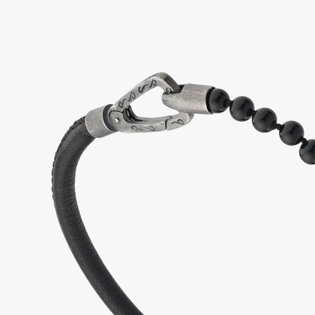 Bracelet with black beads and silver clasp on a white background
