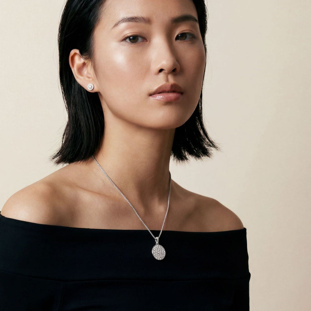 Female model wearing the Moneta Gemstone Pendant in polished silver with white diamonds.