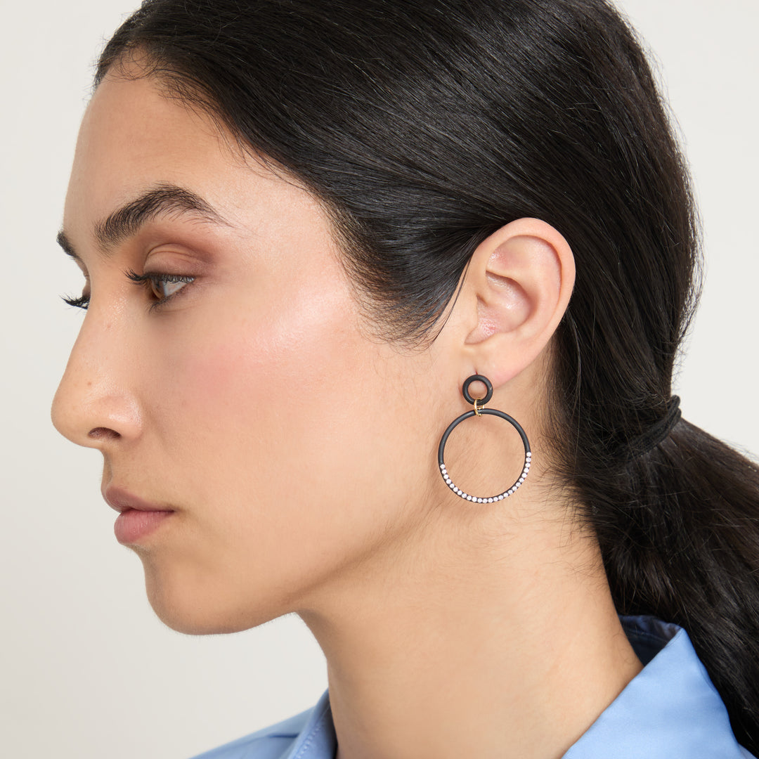 Eclipse Twin Orbit Earrings worn alone by model against neutral background