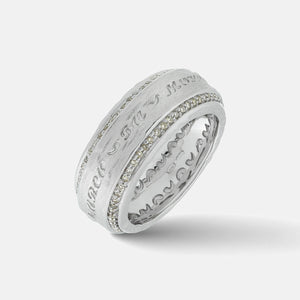 Tilted close-up of The Other Half Collection ring showcasing scalloped interior patterns and frosted white gold script.