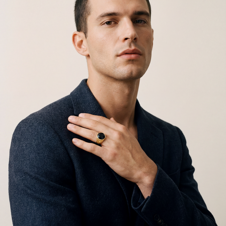 Man wearing a dark coat with a plain background