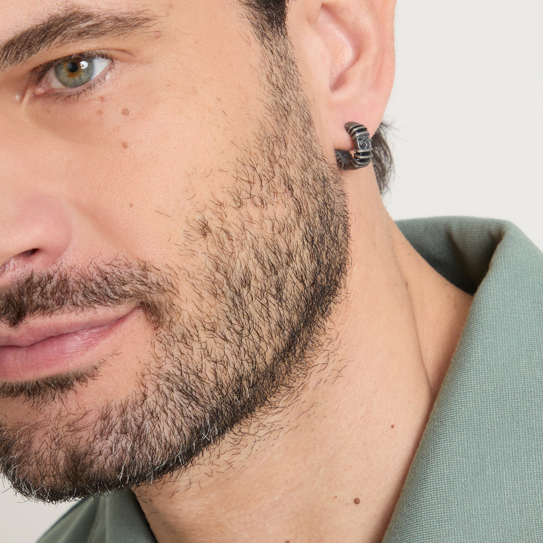 Macro view of hoop earring worn with an olive green collar.
