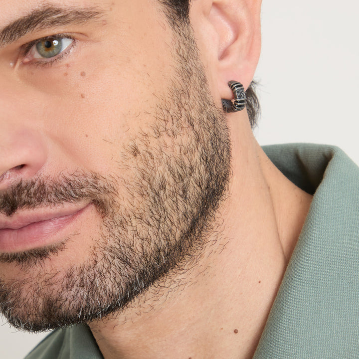 Macro view of hoop earring worn with an olive green collar.