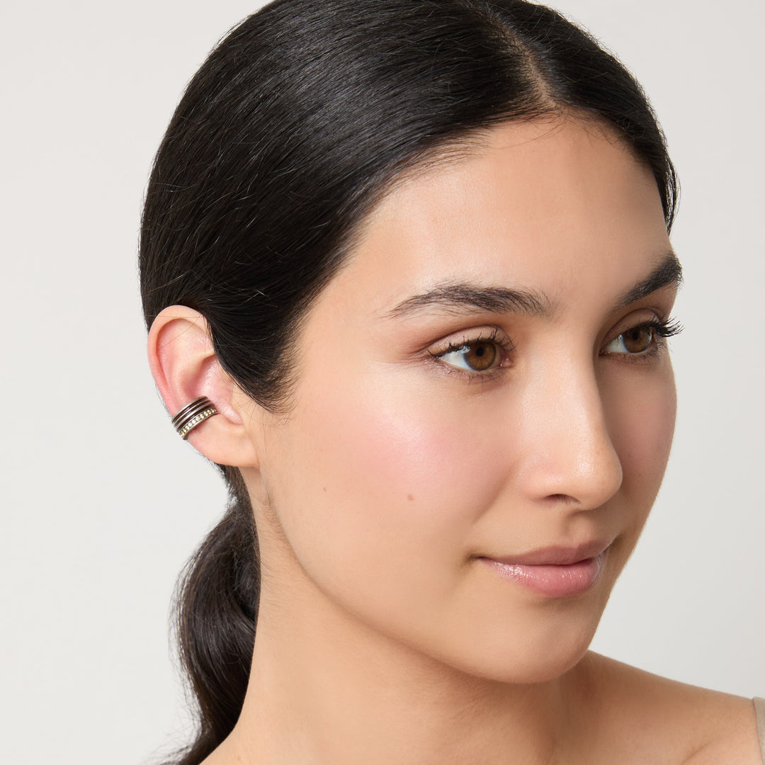 Side profile shot of jeweled ear cuff fitted on a woman.