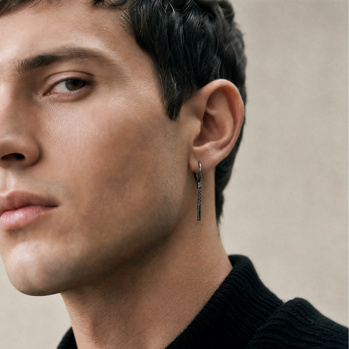 Close-up of a man wearing an earring with a neutral background
