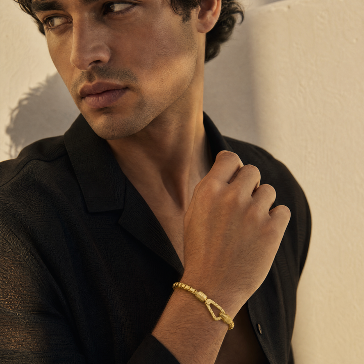 Model wearing the Ulysses Tubular Bracelet in polished yellow gold vermeil with a signature carabiner clasp.