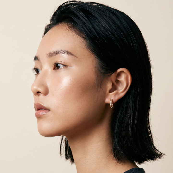 Warrior Ornate Hoop Earring in yellow gold with white diamonds worn by a model.