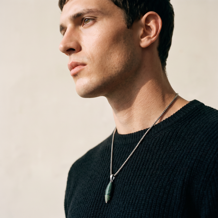 Model wearing the Acies Cocoon Gemstone Pendant in oxidized silver with green enamel and tsavorite garnet