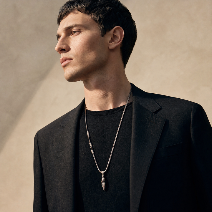 Model wearing the Acies Cocoon Pendant in oxidized silver with black enamel and black leather.