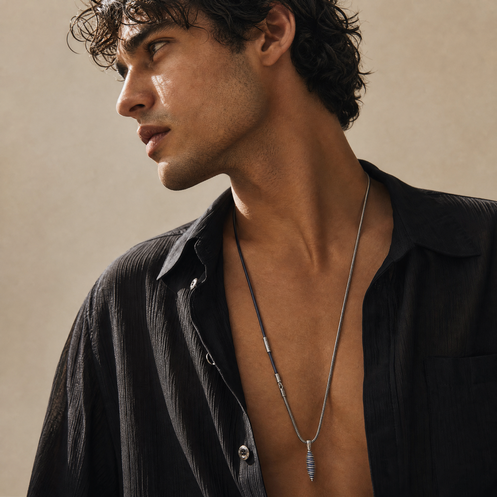 Model wearing the Acies Cocoon Pendant in oxidized silver with blue enamel and blue leather.