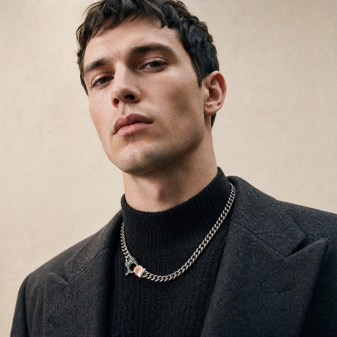 Close-up of a male model wearing the Cuban Edge necklace in oxidised sterling silver with an 18K rose gold vermeil clasp