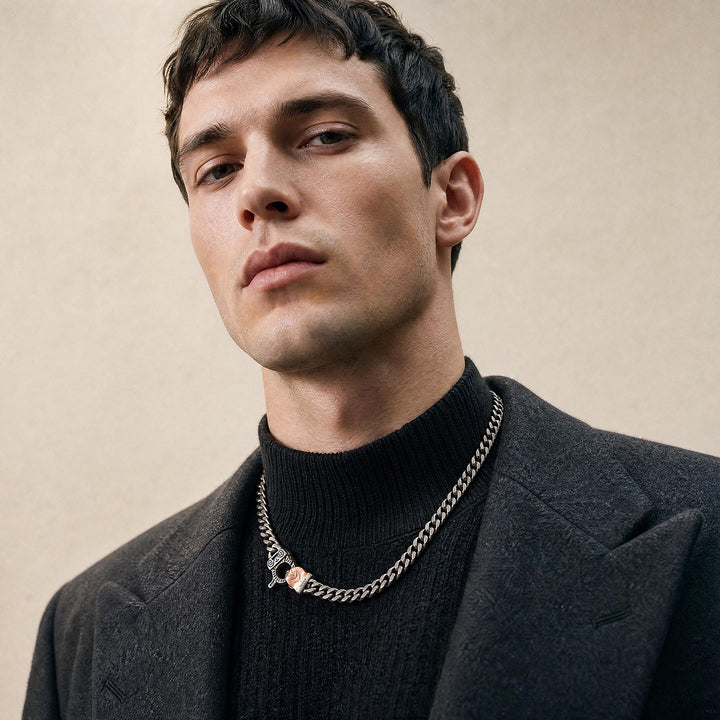 Close-up of a male model wearing the Cuban Edge necklace in oxidised sterling silver with an 18K rose gold vermeil clasp