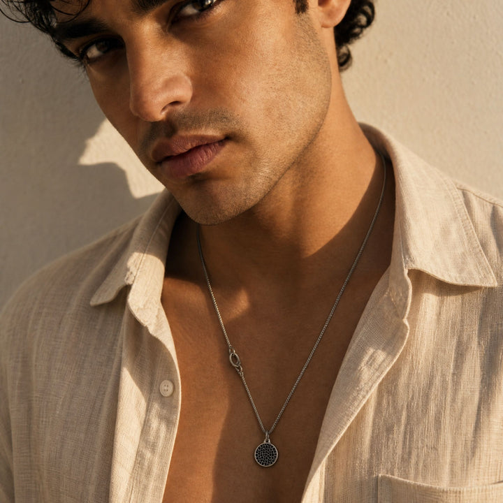Moneta Gemstone Pendant in oxidized silver with black diamonds worn on a necklace by a model.