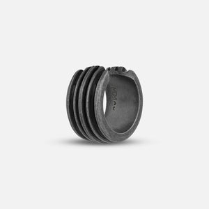 Ribbed cuff in oxidized silver and black enamel on a soft studio gradient.