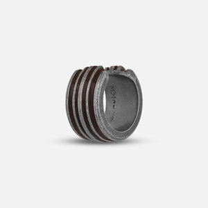 Angled shot of carved band exhibiting bronze lacquer over gradient field.