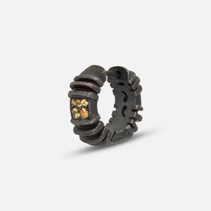 Hoop earring in oxidized silver and amber gems on an isolated grey floor.